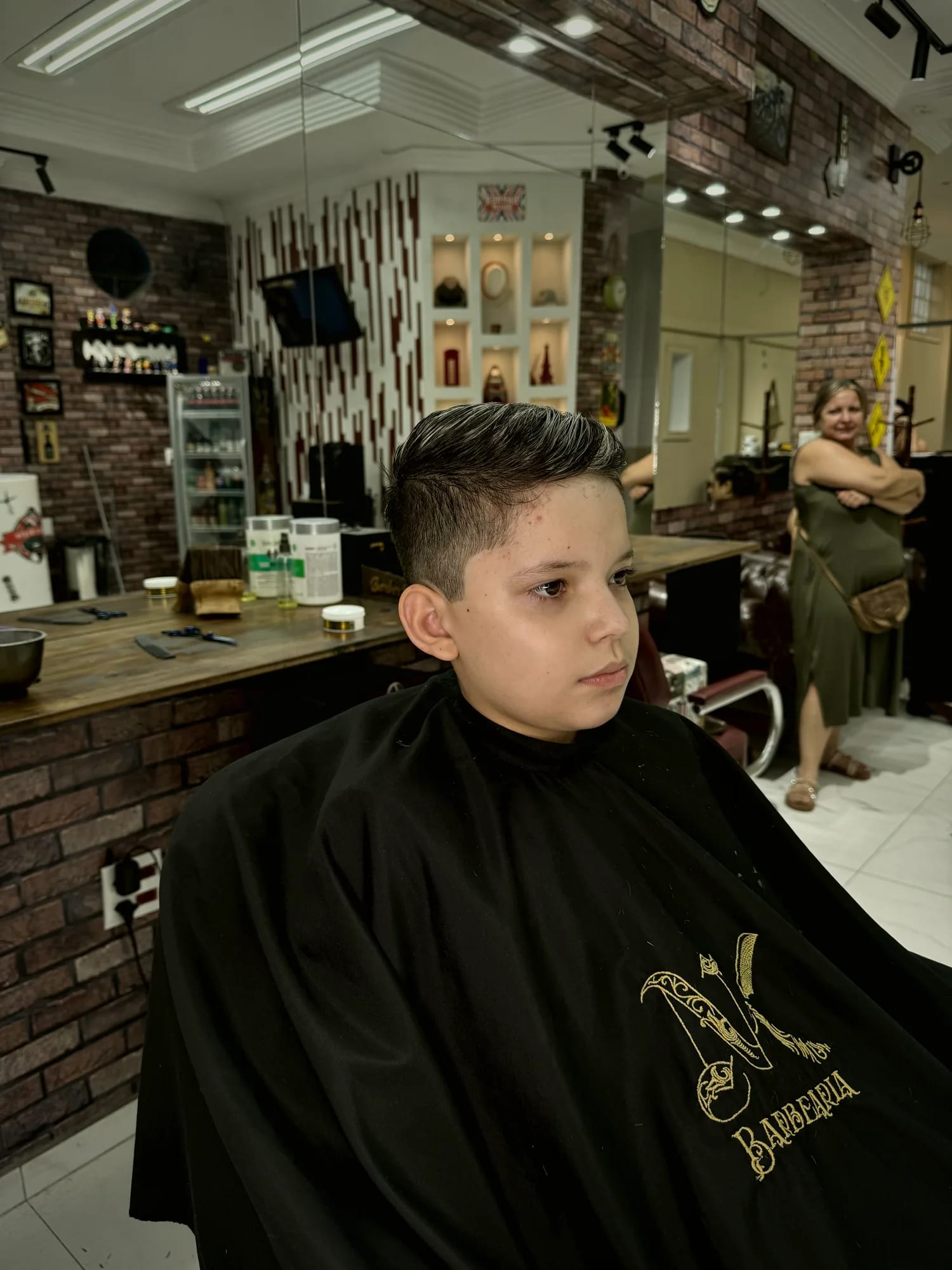 Bancada de madeira e parede de tijolos no interior da NK Barbearia
